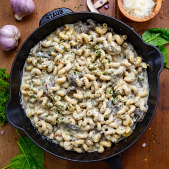 Roasted Garlic Mushroom Pasta in a skillet on a wooden table from overhead.