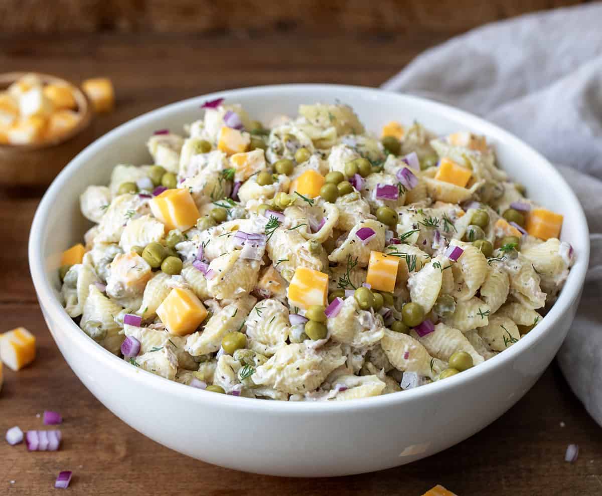 Close up of Tuna Pasta Salad on a wooden table in a white bowl.