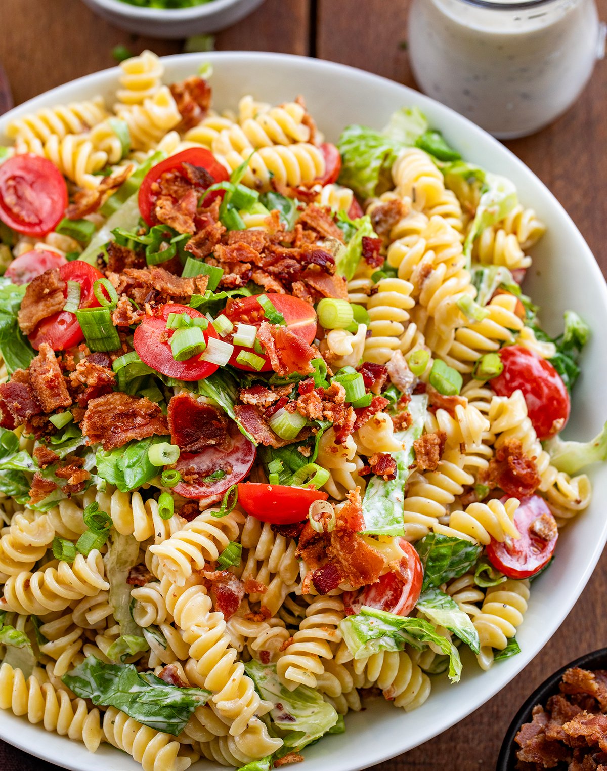 BLT Pasta Salad in a white bowl on a wooden table.