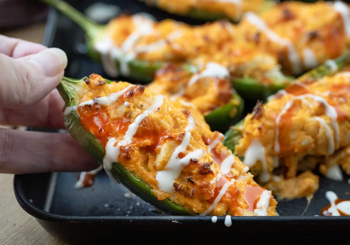 Hand picking up a Buffalo Chicken Jalapeño Popper.