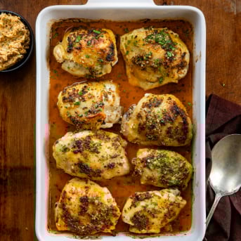 Cowboy Butter Chicken Thighs in a baking dish on a wooden table from overhead.