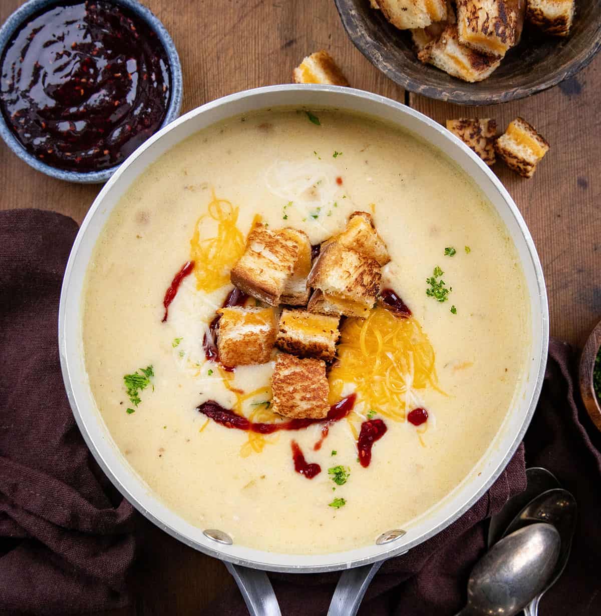 Monte Cristo Soup in a pot on a wooden table from overhead.