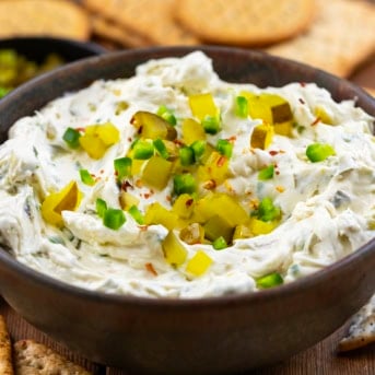 Bowl of Spicy Dill Pickle Dip surrounded by crackers.