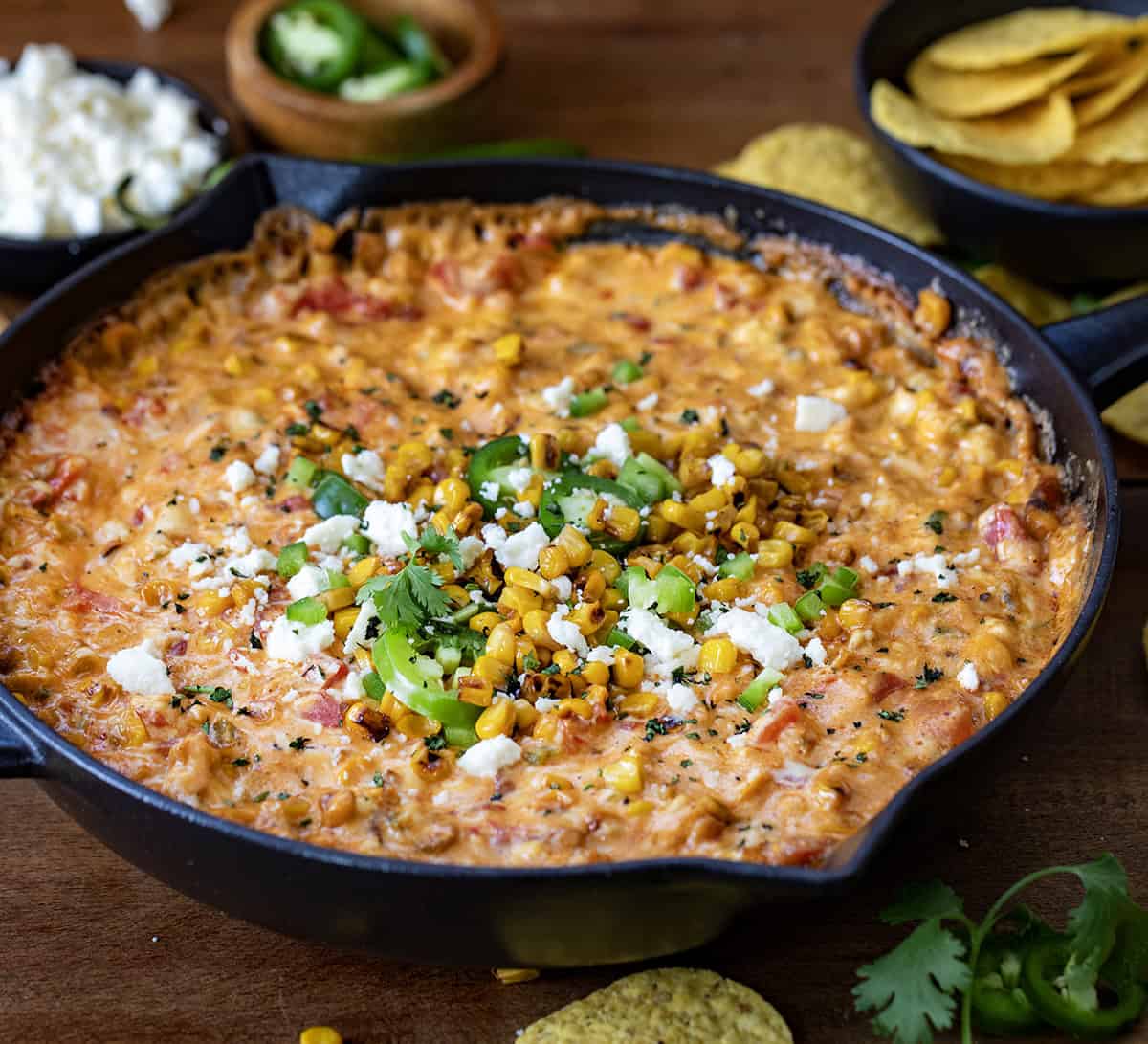Pan of Street Corn Queso on a wooden table.
