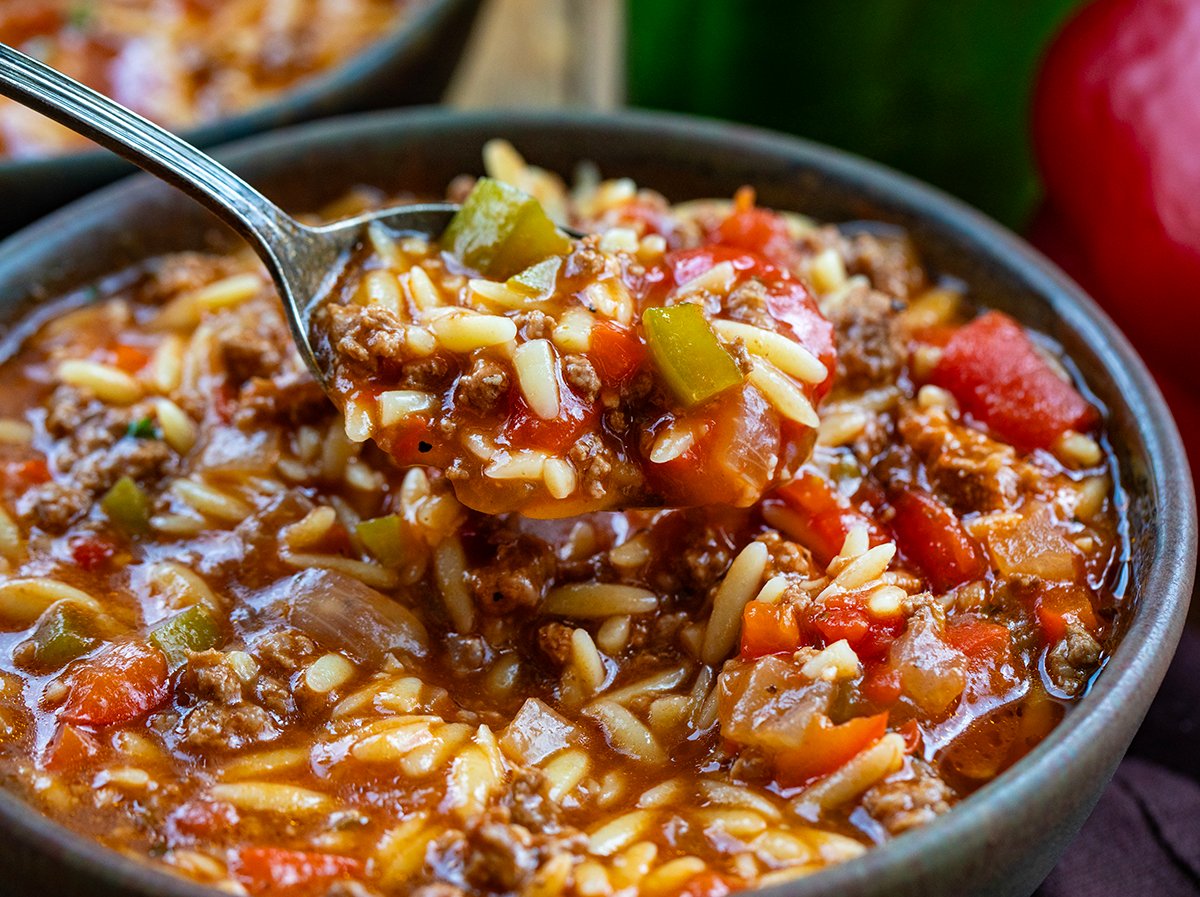 Spoonful of Stuffed Pepper Orzo Soup being held above the bowl.