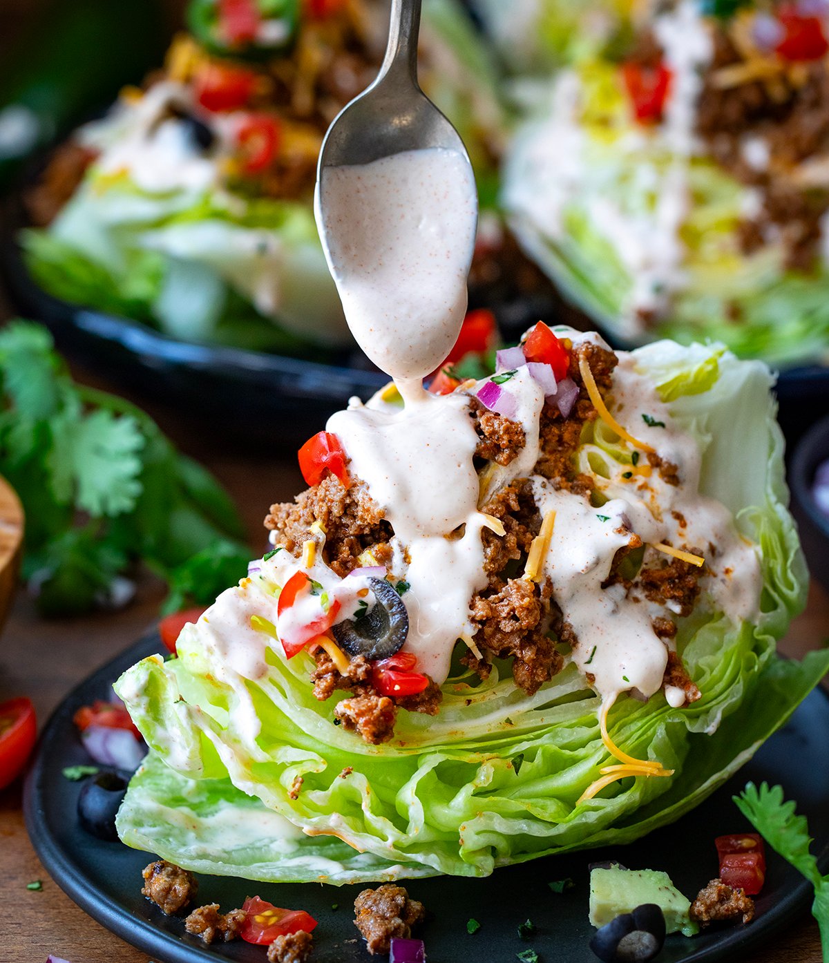Drizzling dressing over a Taco Wedge Salad.