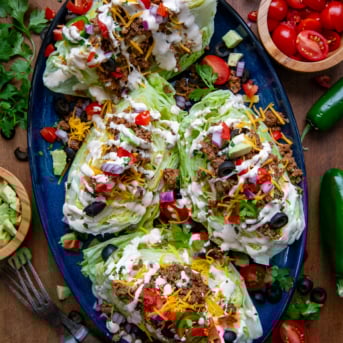 Taco Wedge Salads on a blue platter on a wooden table from overhead.