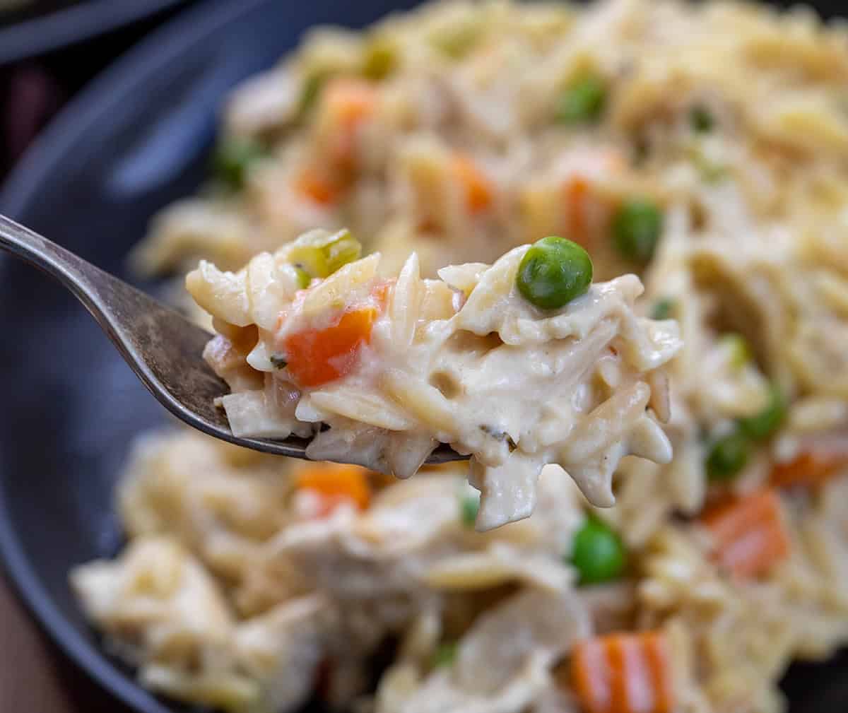 Forkful of Chicken Pot Pie Orzo held above the plate.