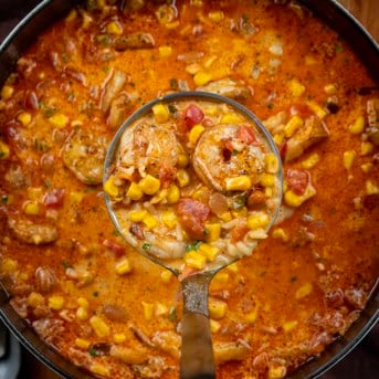 Ladle full of Chipotle Shrimp Soup being held above the pot.