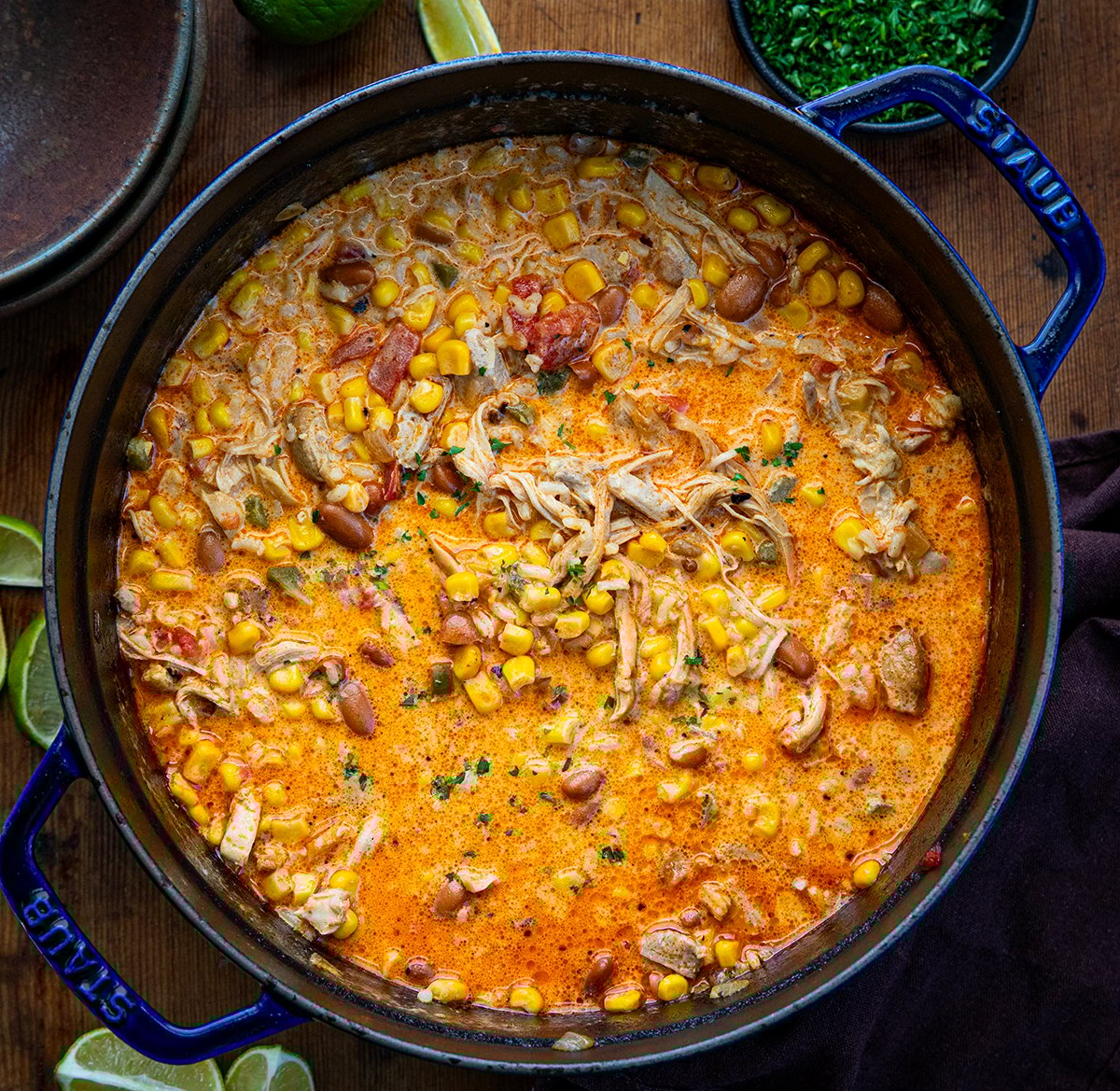Pot of Creamy Chipotle Chicken Soup on a wooden table from overhead.