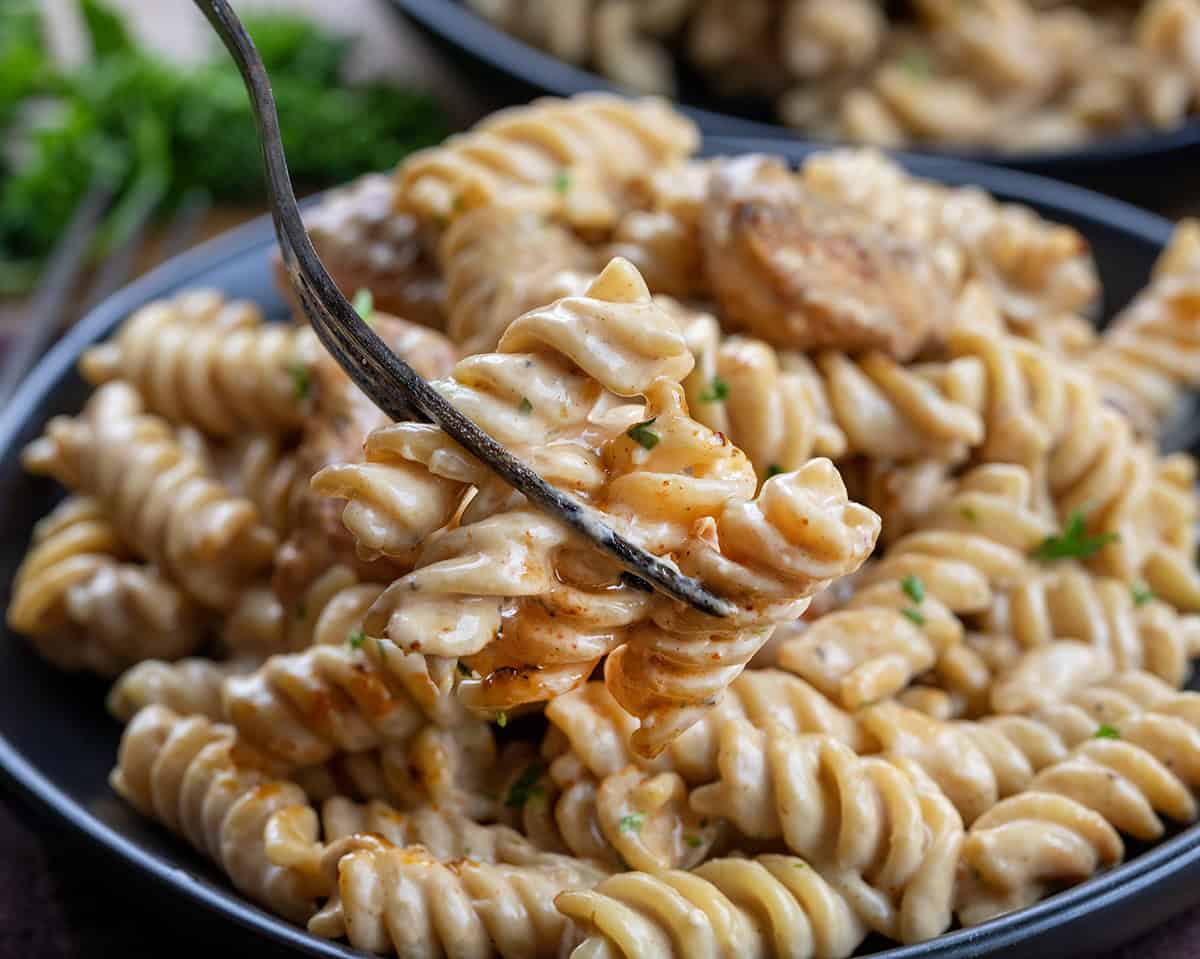 Fork holding Garlic Chicken Rotini noodles on it.