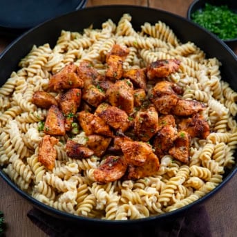 Skillet filled with Garlic Chicken Rotini with the crispy chicken sitting on top of the pasta.