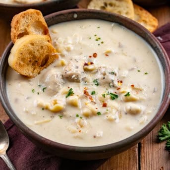 Bowls of Garlic Parmesan Chicken Chowder on a wooden table close up.