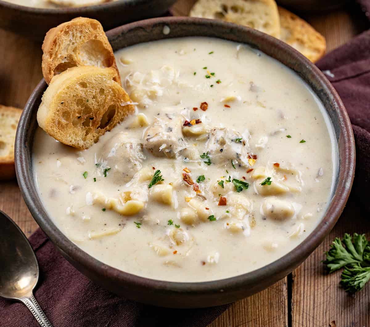 Bowls of Garlic Parmesan Chicken Chowder on a wooden table close up.