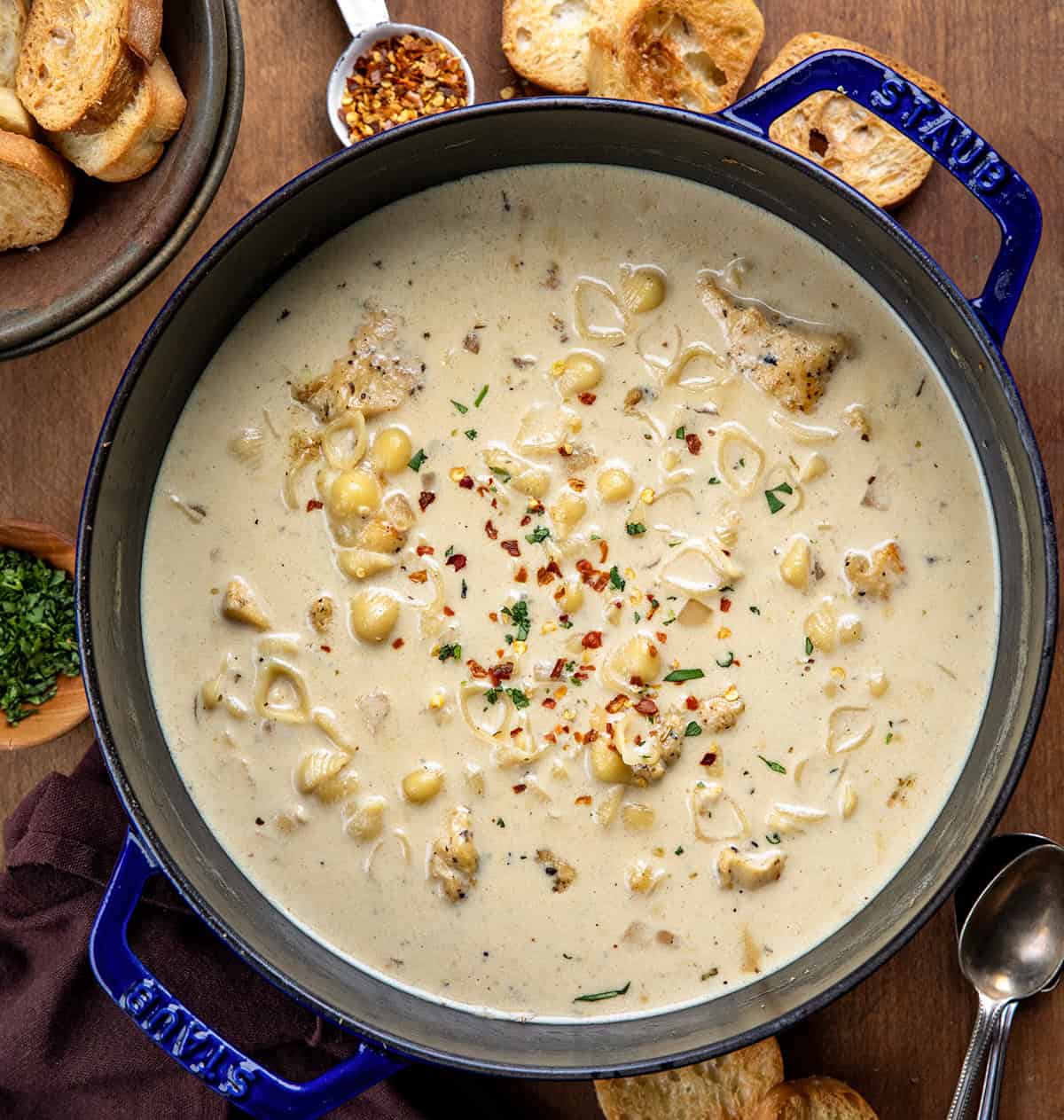 Pot of Garlic Parmesan Chicken Chowder on a wooden table from overhead.