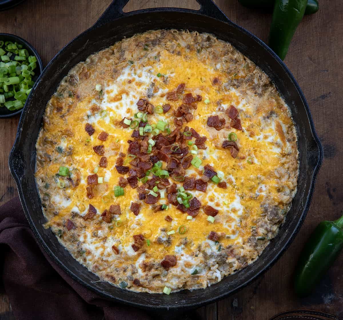 Skillet of Jalapeño Popper Beef and Rice Casserole on a wooden table from overhead.