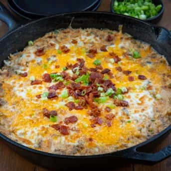 Close up of a skillet of Jalapeño Popper Beef and Rice Casserole on a wooden table.
