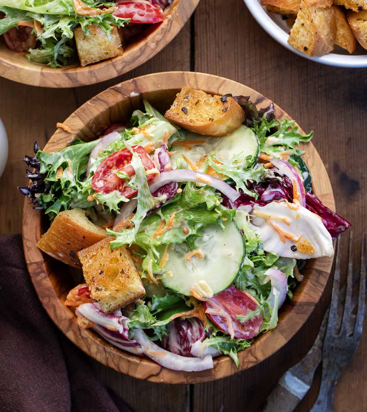 Simple Side Salad in wooden bowls on a wooden table from overhead.