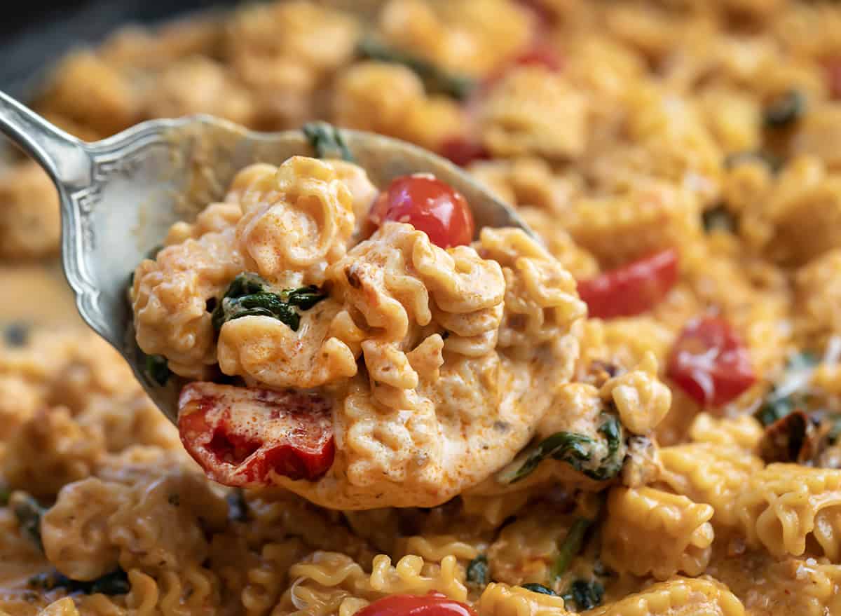 Spoonful of Tuscan Radiatore being held above the skillet.
