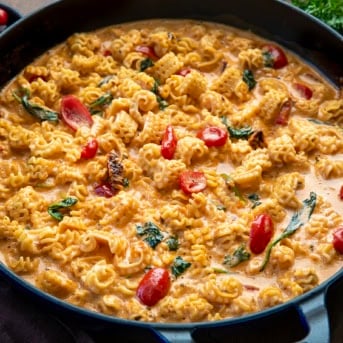 Close up of a skillet of Tuscan Radiatore on a wooden table.
