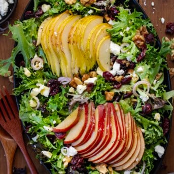 Black platter of Winter Pear Salad on a wooden table.