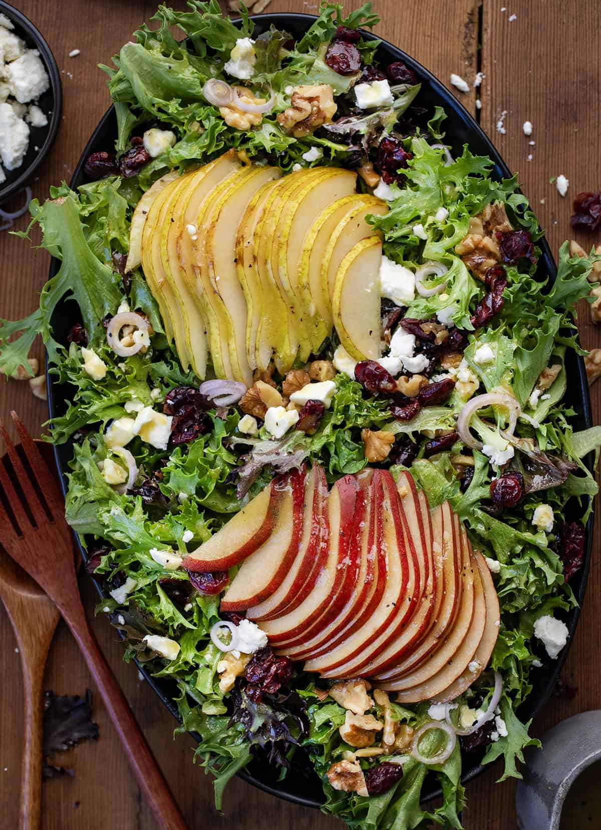 Black platter of Winter Pear Salad on a wooden table.