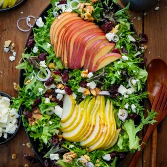 Black platter of Winter Pear Salad on a wooden table.
