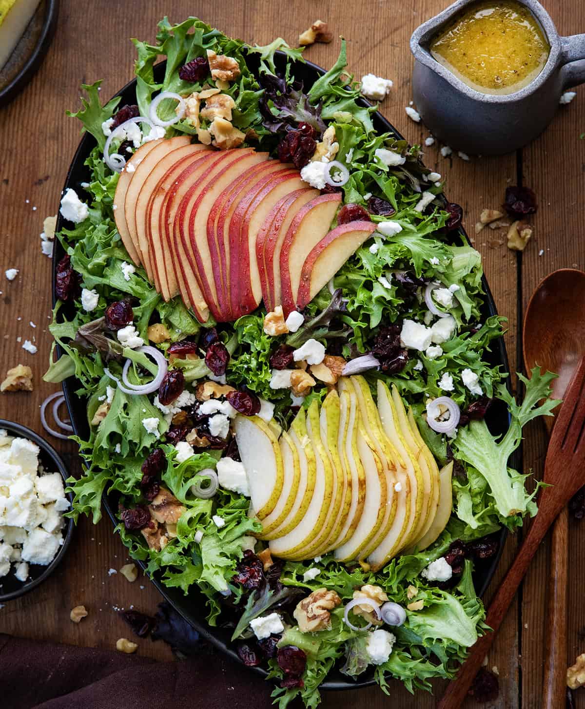 Black platter of Winter Pear Salad on a wooden table. 