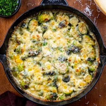 Brussels Sprouts Gratin in a pan on a wooden table from overhead.