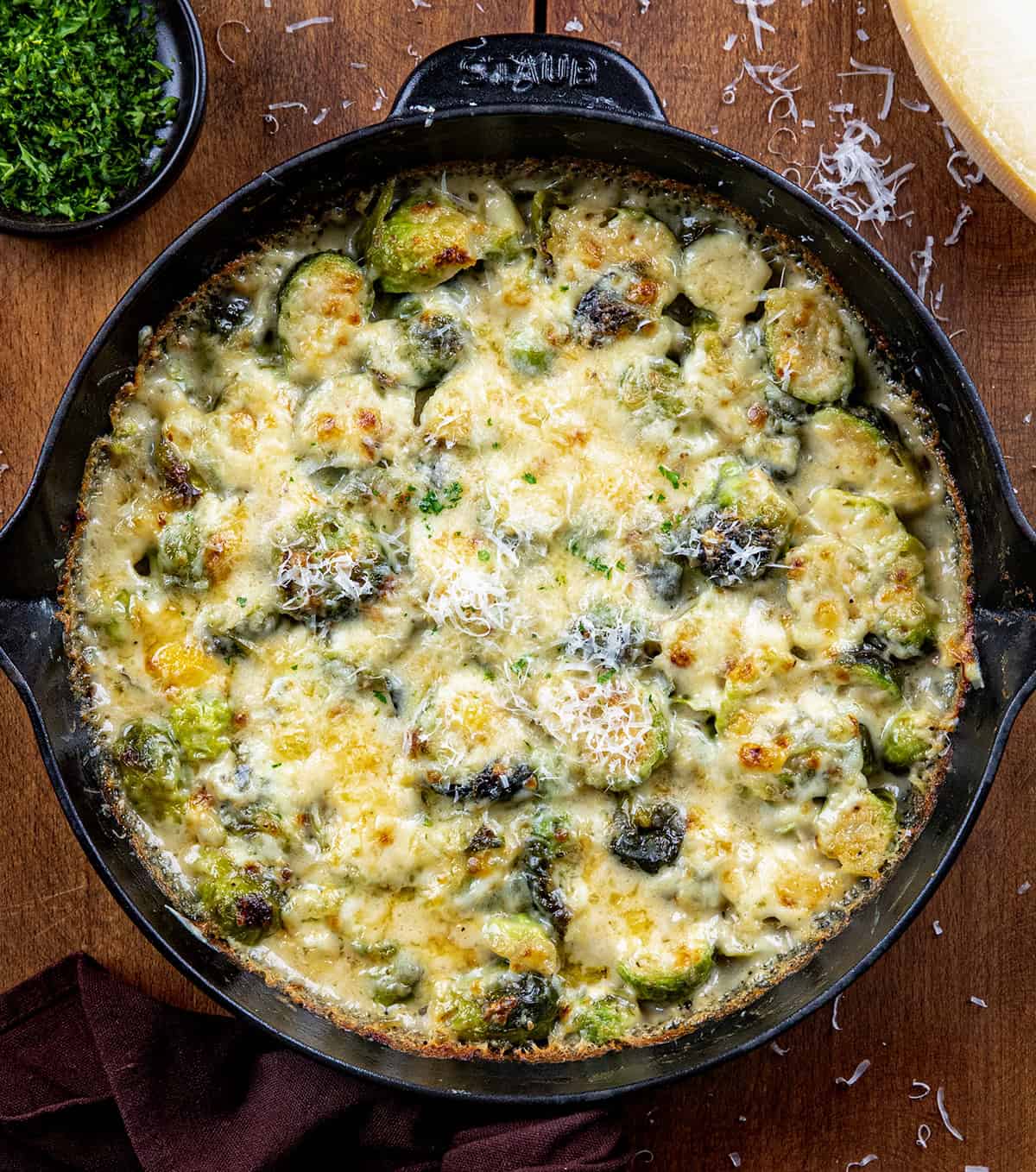 Brussels Sprouts Gratin in a pan on a wooden table from overhead.
