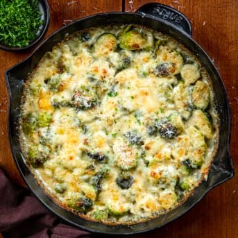 Brussels Sprouts Gratin in a pan on a wooden table from overhead.