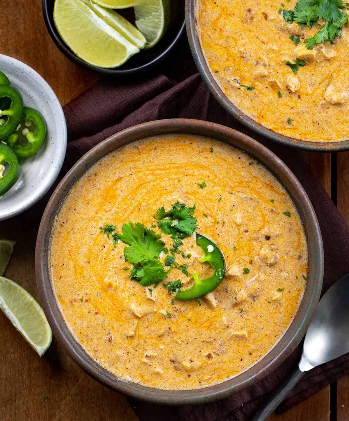 Bowls of Chipotle Chicken Chili on a wooden table from voerhead.