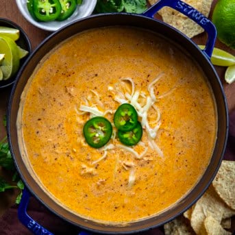 Pot of Chipotle Chicken Chili on a wooden table with fresh jalapeno from overhead.
