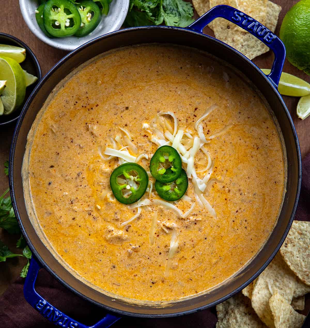 Pot of Chipotle Chicken Chili on a wooden table with fresh jalapeno from overhead.