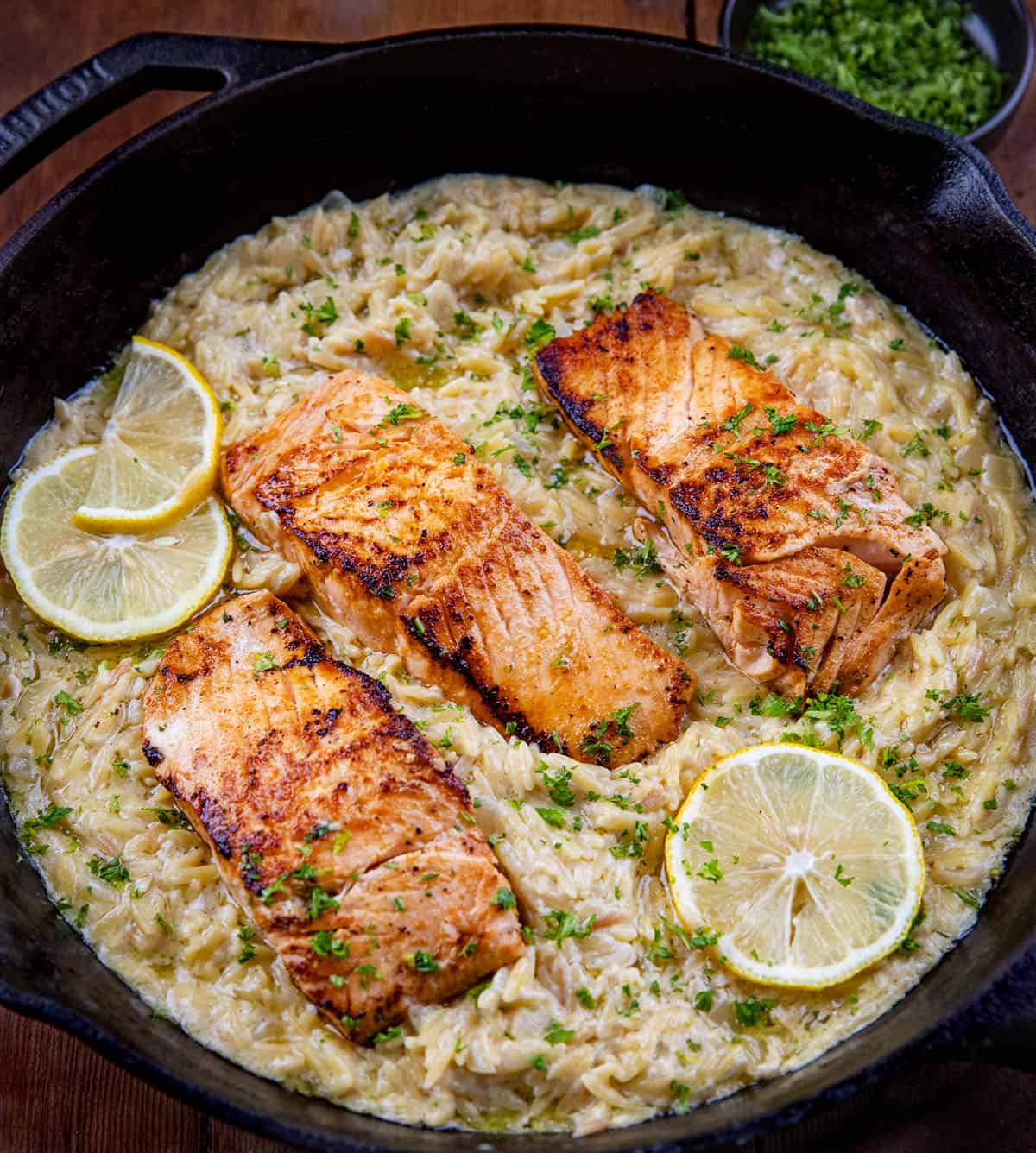 Close up of a skillet with Creamy Lemon Orzo with Salmon.