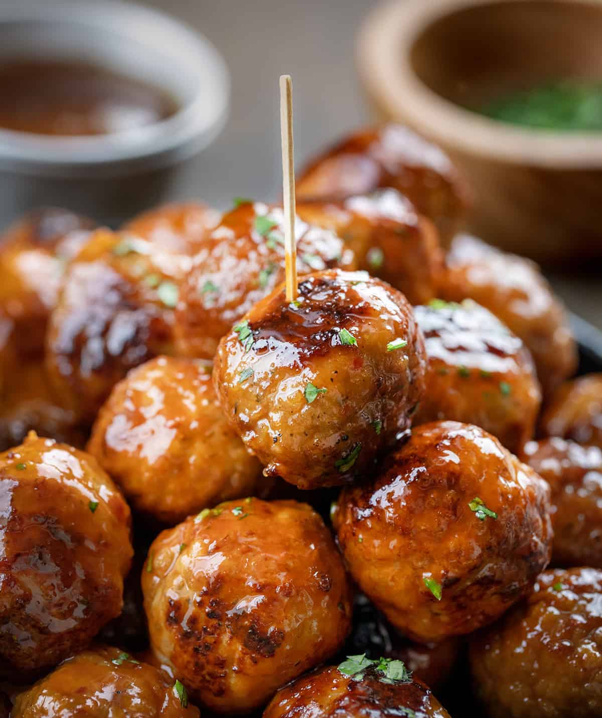 Pile of Honey Buffalo Meatballs with top meatball speared with a toothpick.