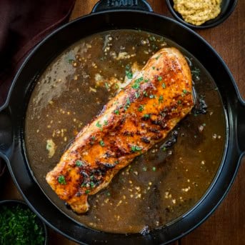 Maple Dijon Pork Tenderloin in a pan on a wooden table from overhead.