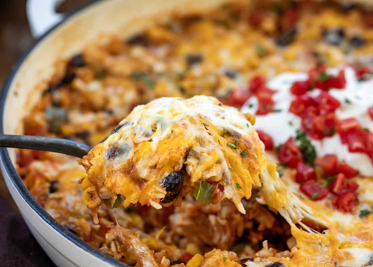 Scoop of Southwest Chicken Skillet being held above the pan.