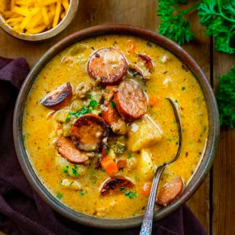 Bowl of Spicy Cajun Sausage Potato Soup with a spoon in it from overhead.