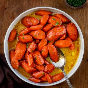 Bowl of Candied Carrots on a wooden table from overhead.