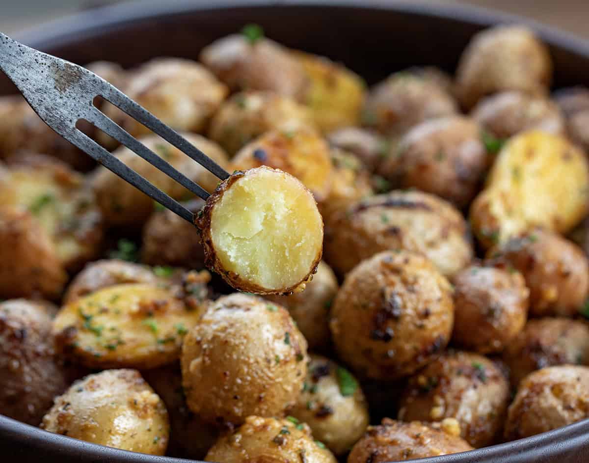 Try Cowboy Mayo Roasted Potatoes for a flavorful side dish! Simple, delicious, and perfect for any meal or get-together! Fork with half a Cowboy Mayo Roasted Potato on it showing tender inside.