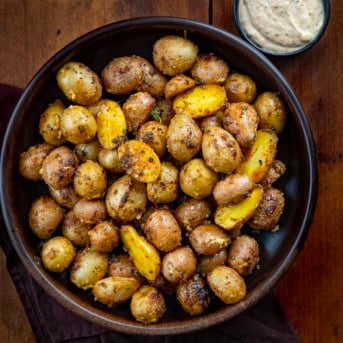 Bowl of Cowboy Mayo Roasted Potatoes on a wooden table from overhead.