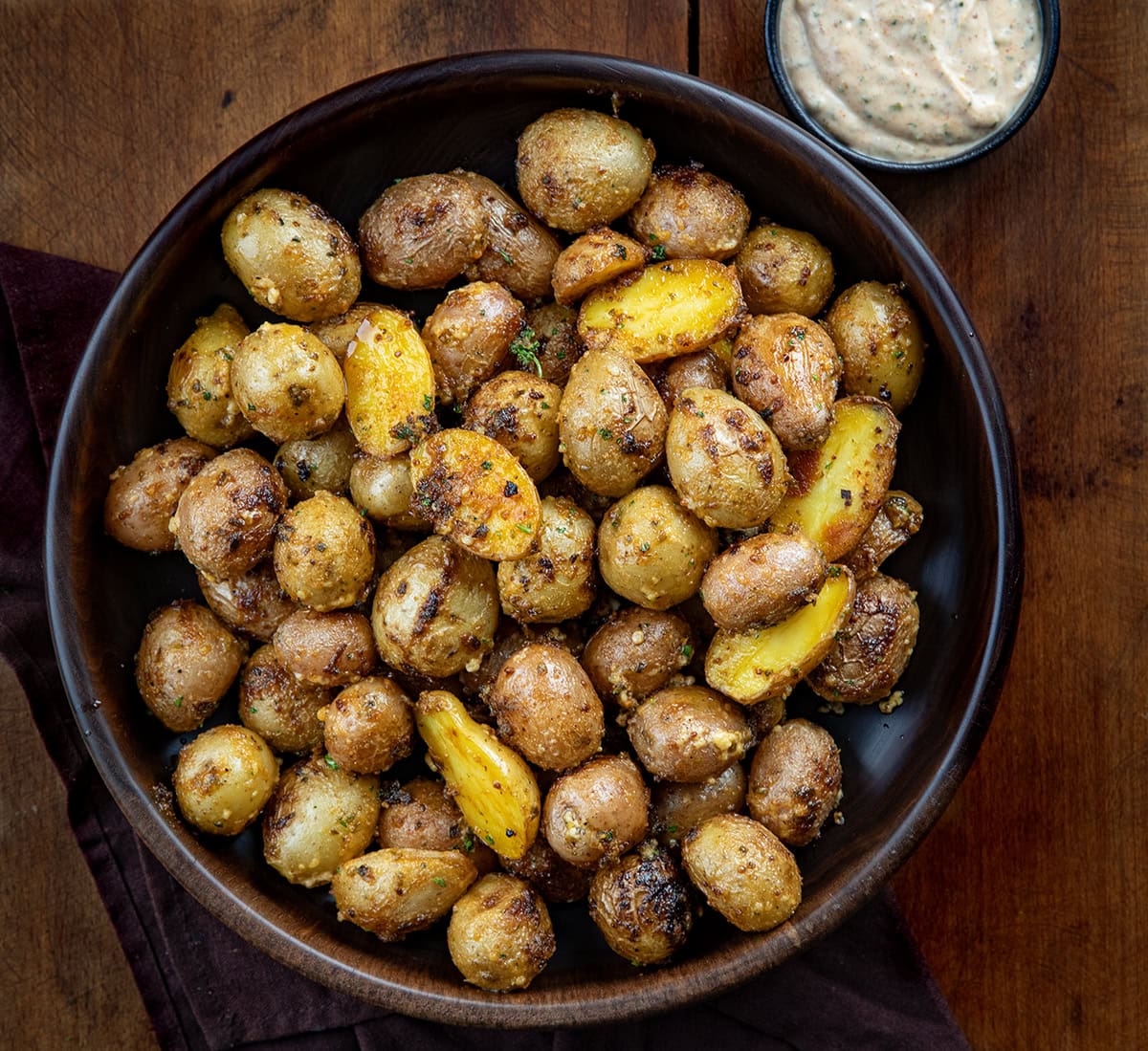 Try Cowboy Mayo Roasted Potatoes for a flavorful side dish! Simple, delicious, and perfect for any meal or get-together! Bowl of Cowboy Mayo Roasted Potatoes on a wooden table from overhead.