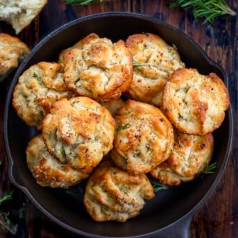 Focaccia Muffins in a small black skillet on a wooden table from overhead.