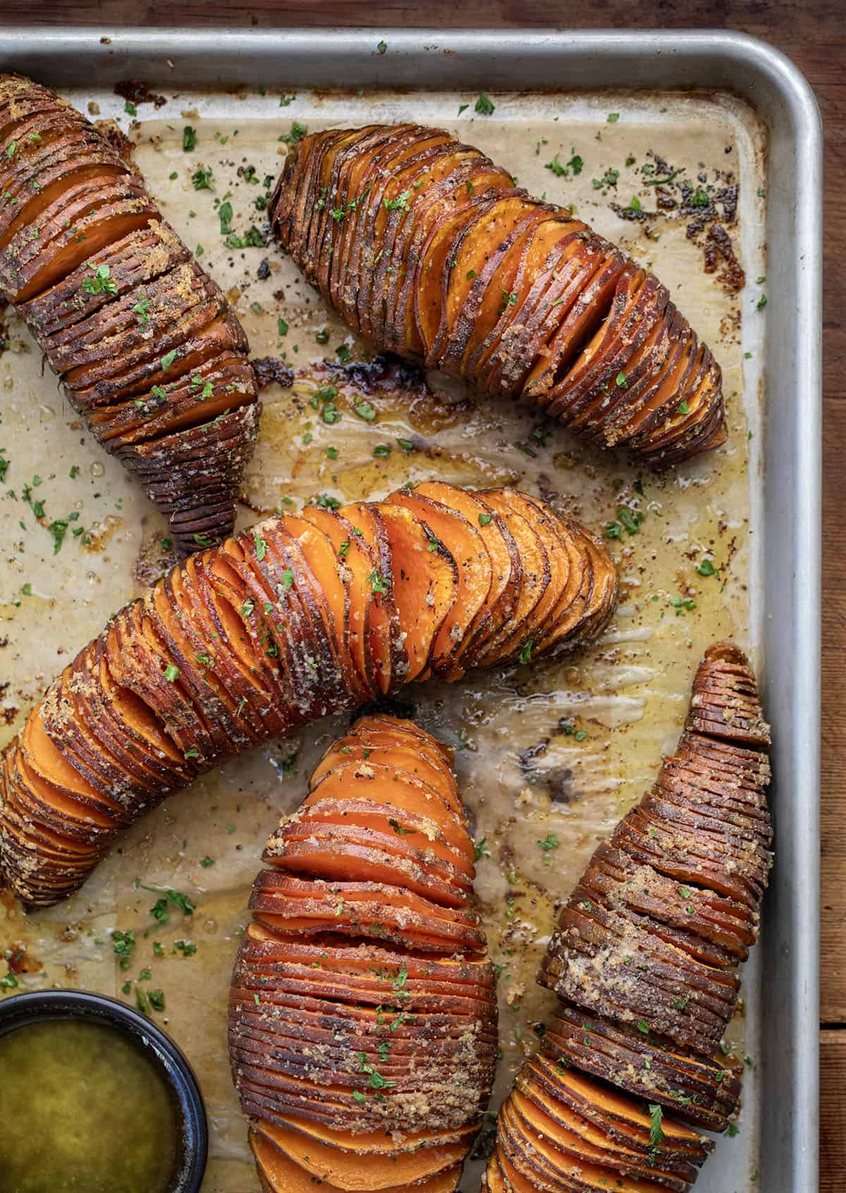 Crispy on the edges and buttery in the center, these Hasselback Sweet Potatoes are an easy side dish that looks extra special on the table! Hasselback Sweet Potatoes on a sheet pan from overhead.
