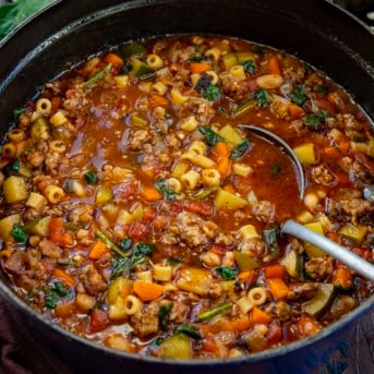 Pot of Minestrone Soup with Sausage with a ladle in it.