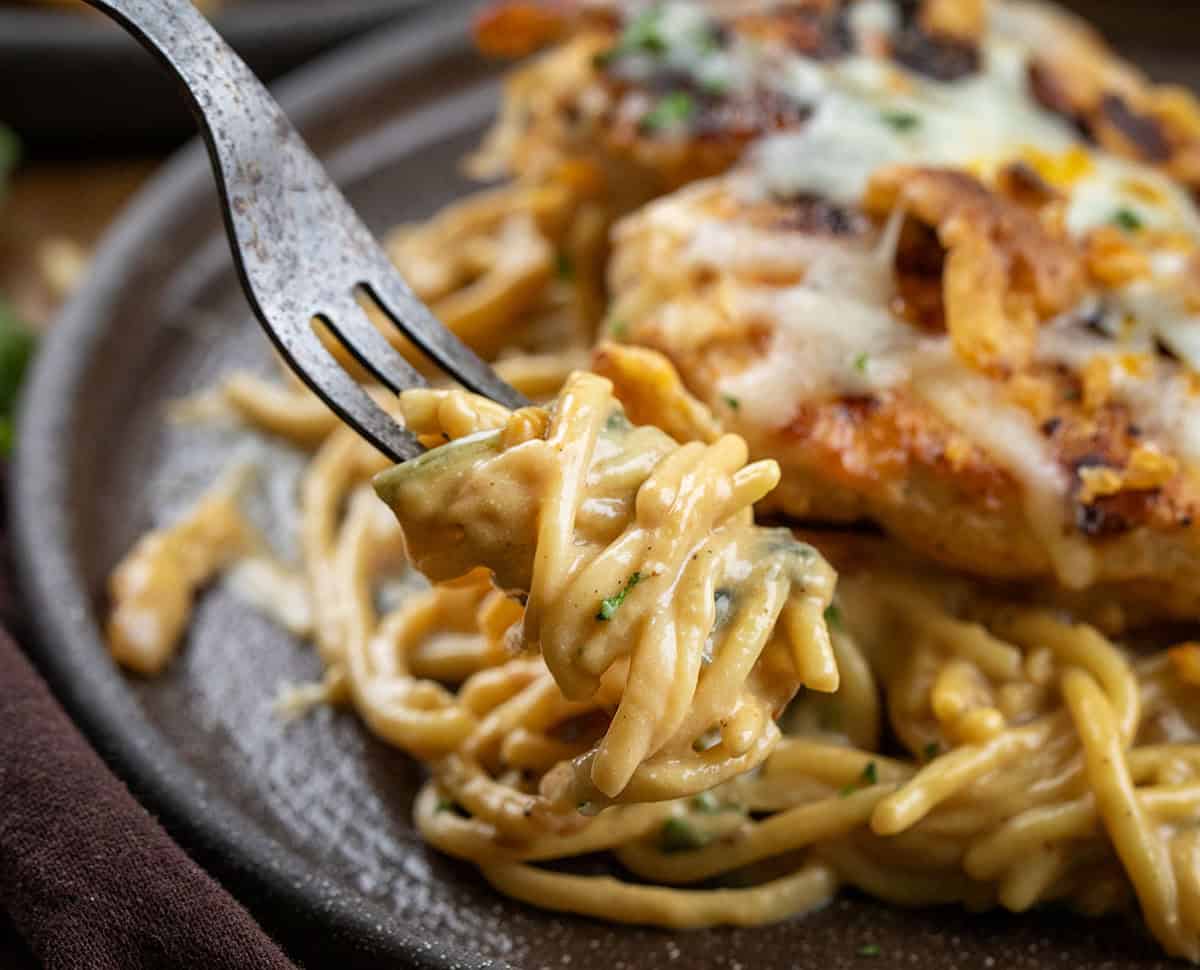 Forkful of Monterey Chicken Spaghetti being held above the plates.