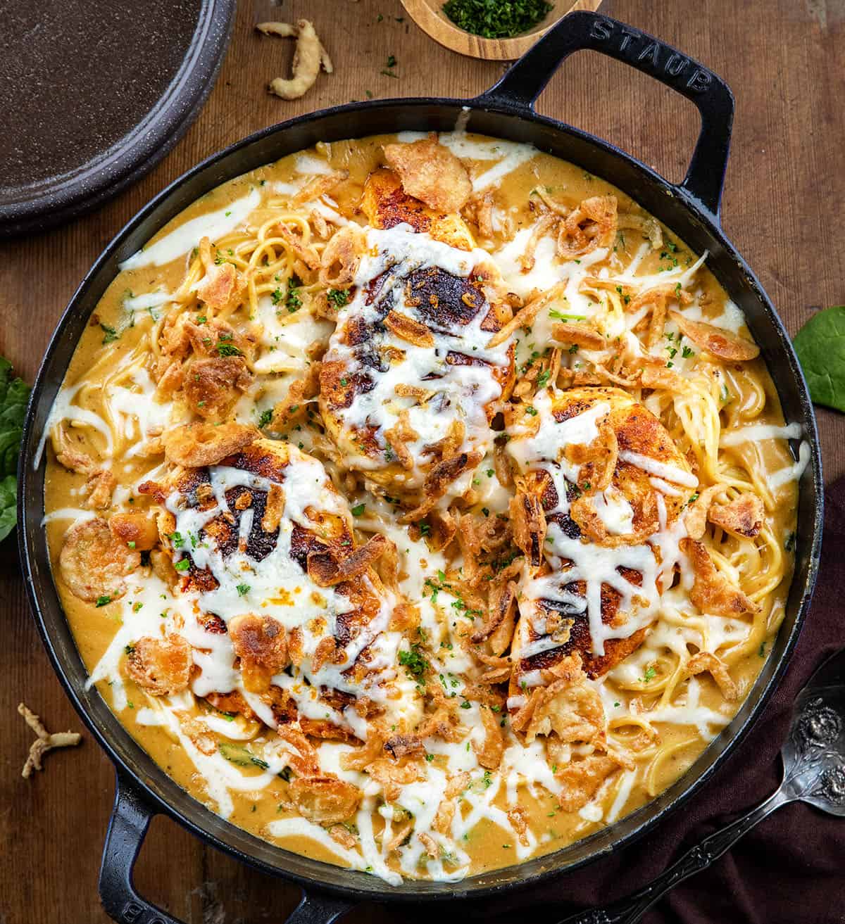 Skillet of Monterey Chicken Spaghetti on a wooden table from overhead.
