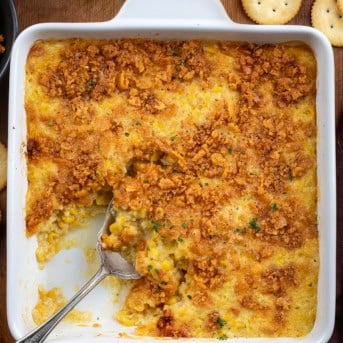 Dish filled with Scalloped Corn and a spoon in the dish.