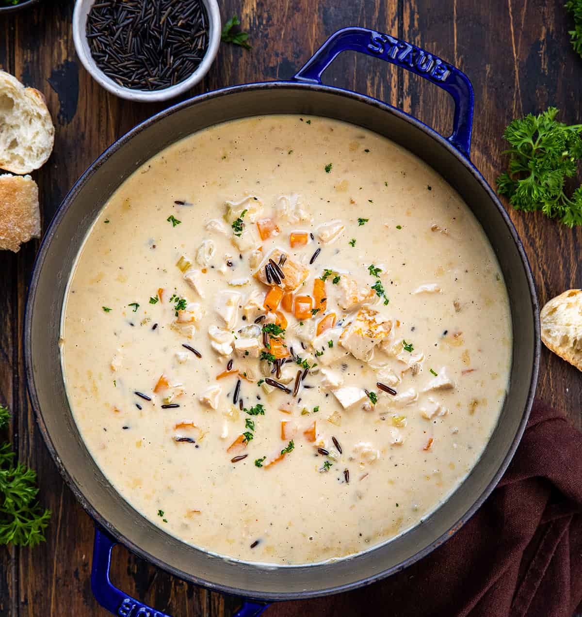 Pot of Turkey Wild Rice Soup on a wooden table from overhead. 